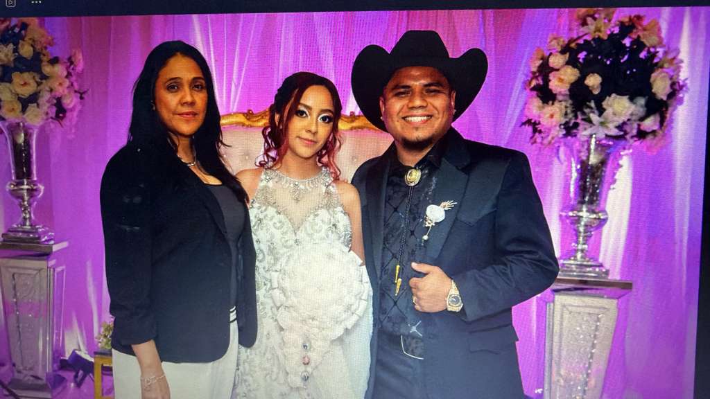 Julia Guerra with newlyweds at a formal wedding reception